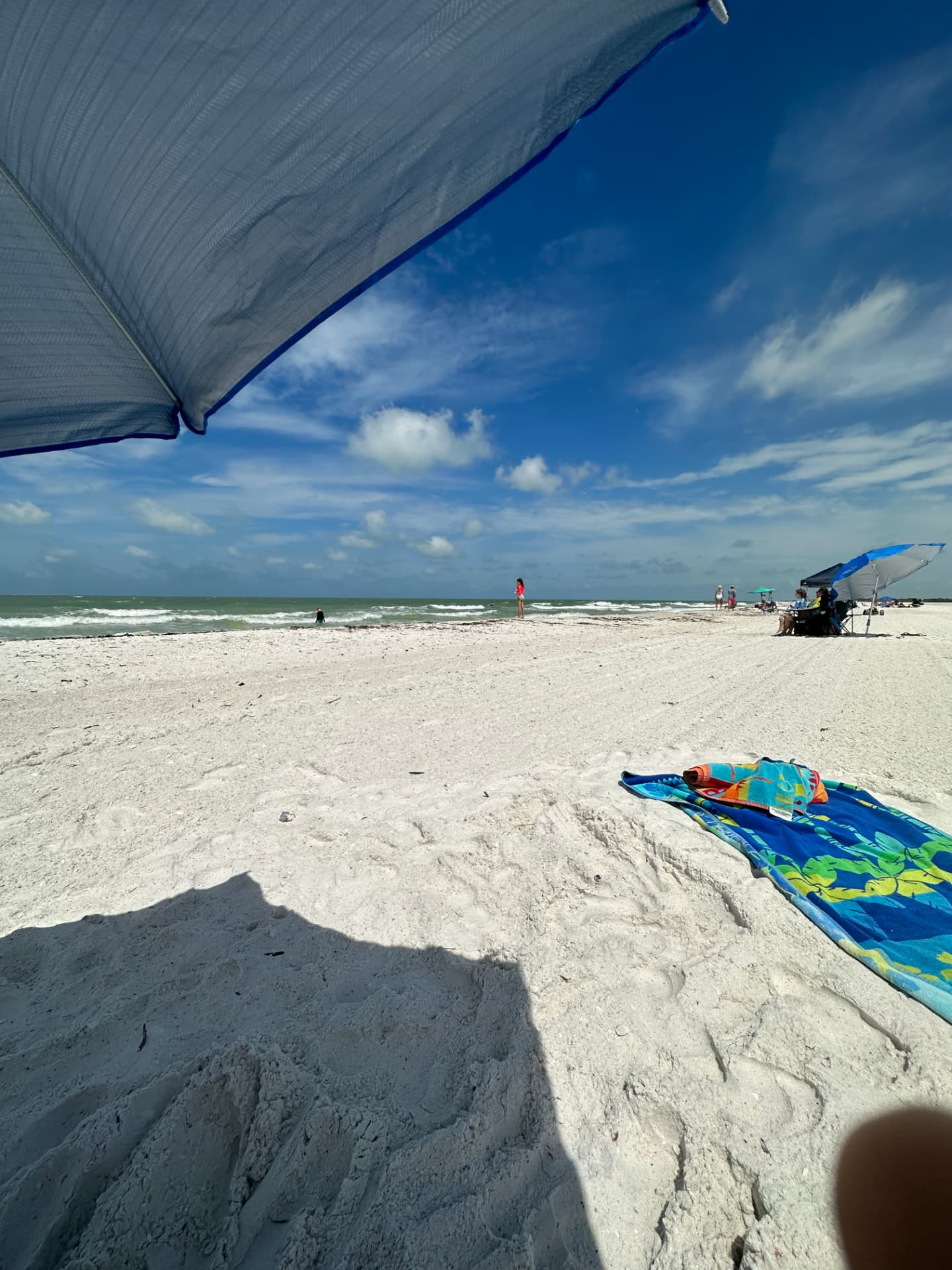 White sand beach with umbrella and chairs near Pirates Cove Marco Island