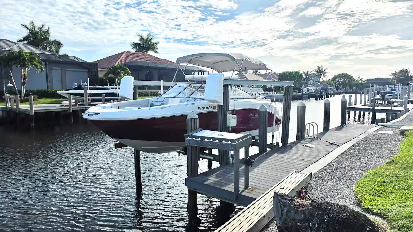 Boat on the private dock and lift at Pirates Cove Marco Island canal-front vacation rental