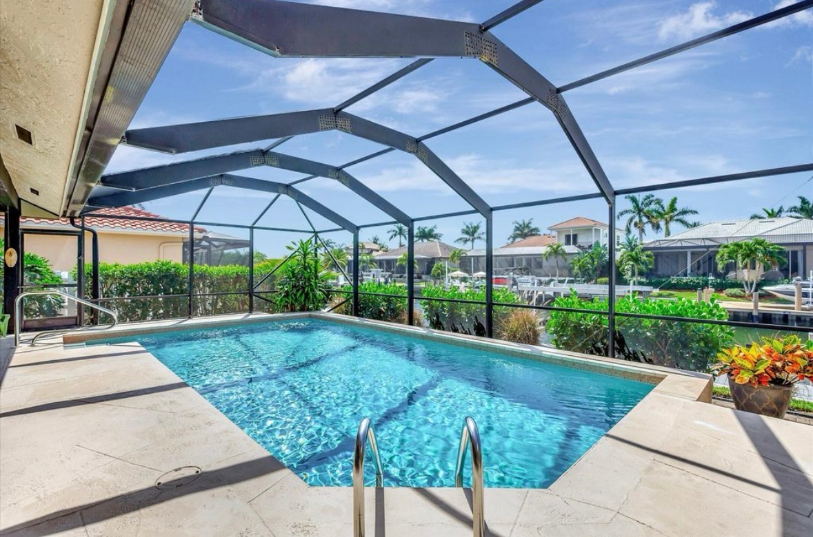 Pool ladder and canal view inside the screened lanai at Pirates Cove Marco Island