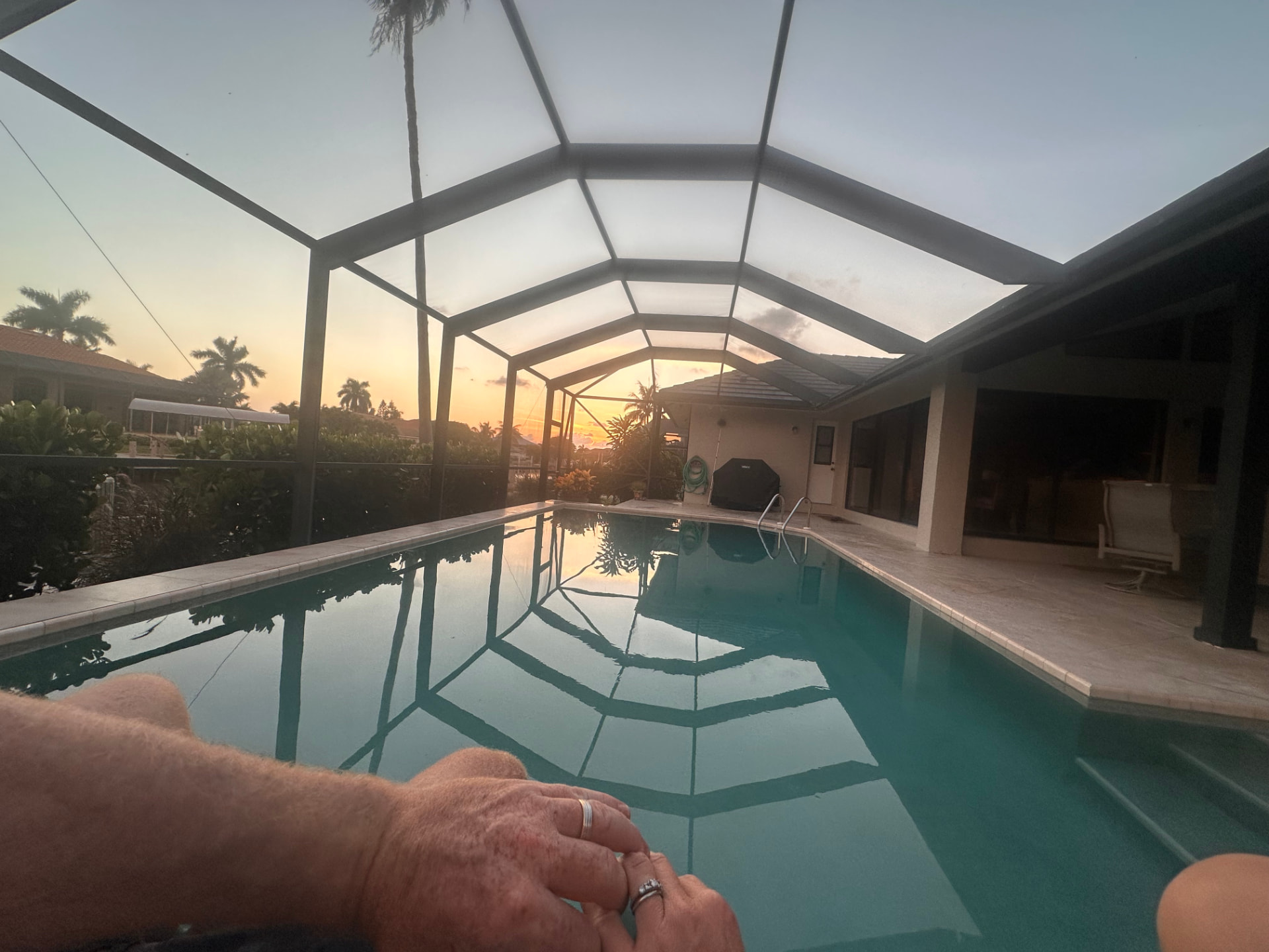 Sunset over the screened pool enclosure at Pirates Cove Marco Island
